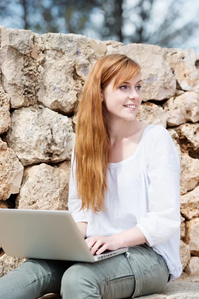 Kobieta pracuje na jej laptopie siedzi myślenia — Zdjęcie stockowe