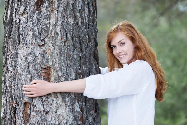 Jolie femme étreignant un arbre — Photo