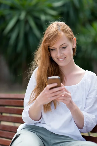 Jovem mulher enviando um SMS — Fotografia de Stock