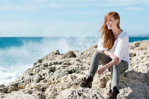 Pretty woman sitting on rocks — Stock Photo, Image