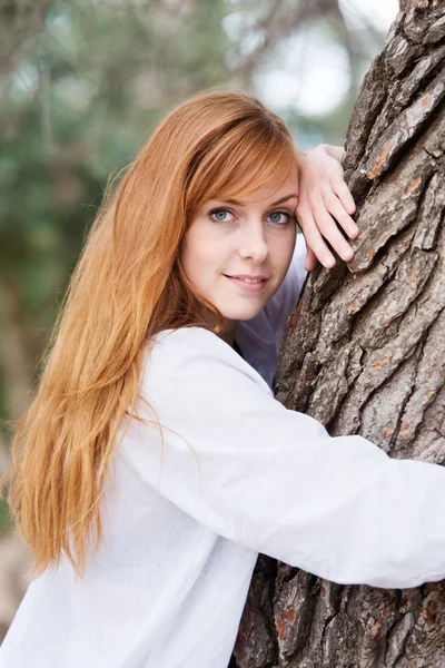 Красивая женщина, прислонившаяся к дереву — стоковое фото