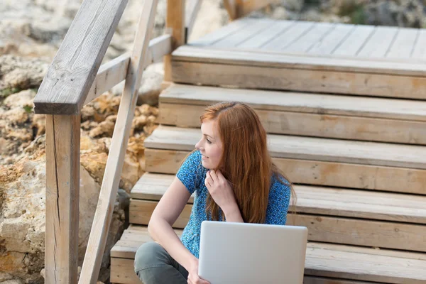 Woman sitting thinking with her laptop — Stock Photo, Image