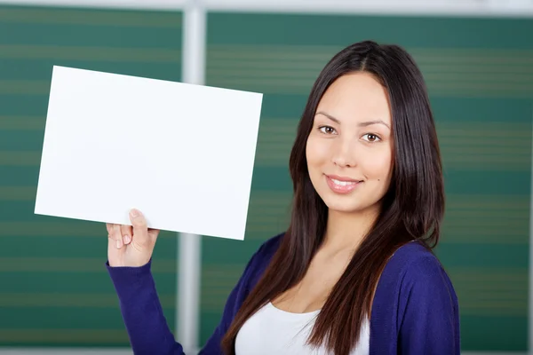 Estudante do sexo feminino exibindo papel branco — Fotografia de Stock
