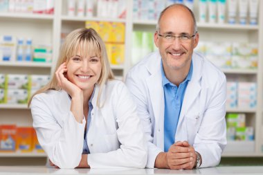 Pharmacists Leaning On Pharmacy Counter clipart