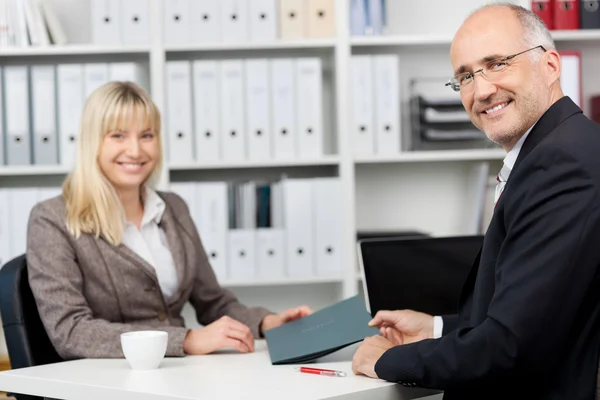 Affärsman och kvinnlig kandidat sitter vid skrivbord — Stockfoto