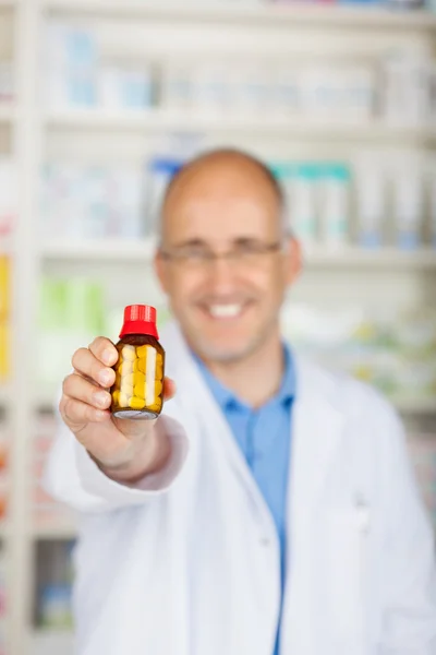 Botella de la medicina de la tenencia del farmacéutico en farmacia —  Fotos de Stock