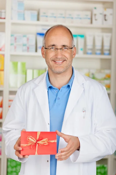 Farmacista in possesso di regalo in farmacia — Foto Stock