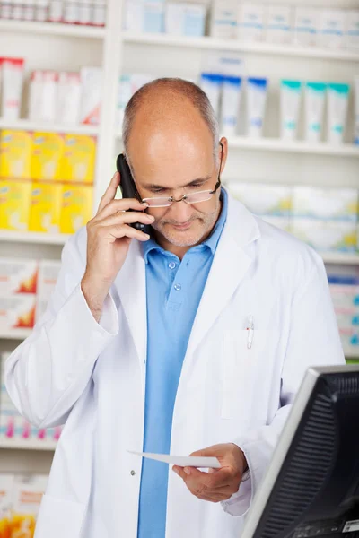Pharmacist Holding Prescription Paper While Using Cordless Phone — Stock Photo, Image