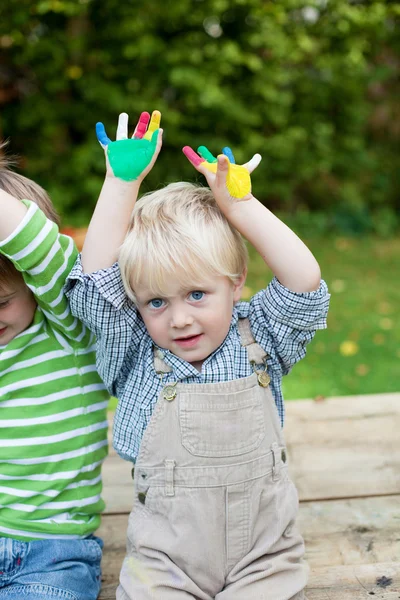 Два маленьких мальчика, показывающих свои раскрашенные руки — стоковое фото