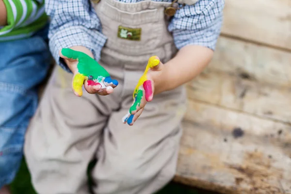 Boy looking on his colorful hands — Stock Photo, Image