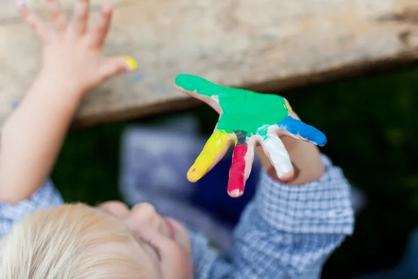 Dulce niño mostrando su mano colorida — Foto de Stock