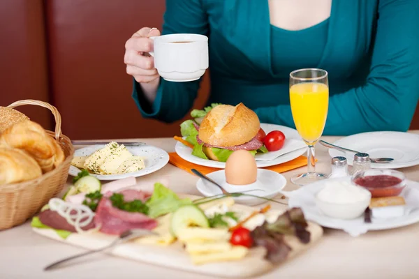 Femme prenant le petit déjeuner dans un café — Photo