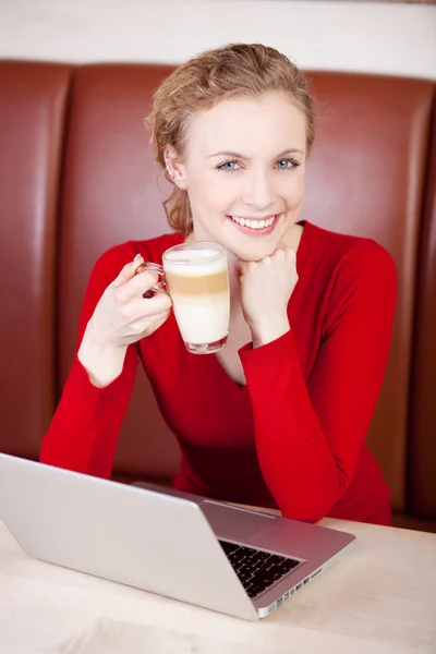 Vrouw die werkt met laptop terwijl het hebben van koffiepauze — Stockfoto