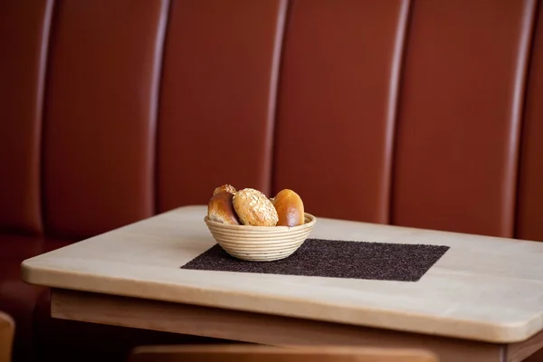 Cesta de pan y mantel en la mesa — Foto de Stock