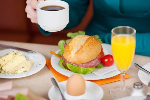 Женщина-клиент завтракает за столом кофейни — стоковое фото