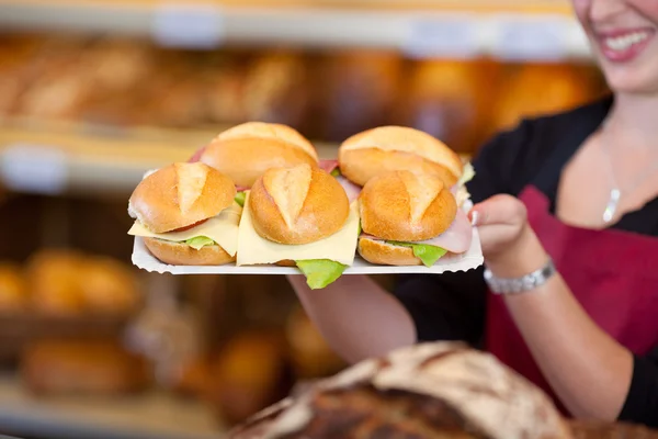 Coffeeshop-Mitarbeiterin hält Tablett voller Burger — Stockfoto