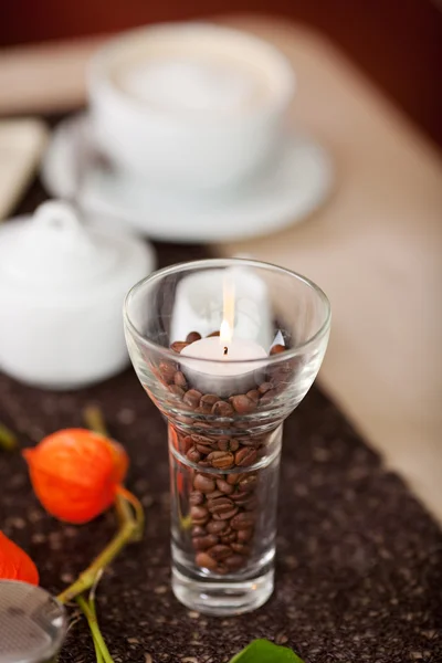 Zapálil svíčku na kávová zrna v držáku — Stock fotografie