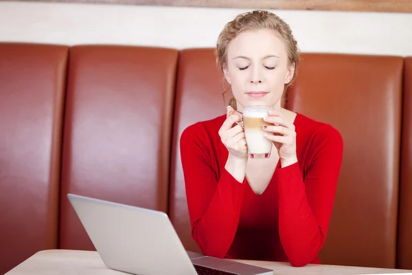 Mujer disfrutando de café con leche en la cafetería —  Fotos de Stock