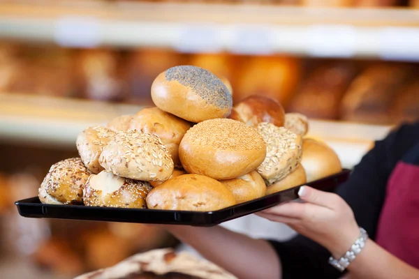 Frau hält in Bäckerei verschiedene Brötchen — Stockfoto