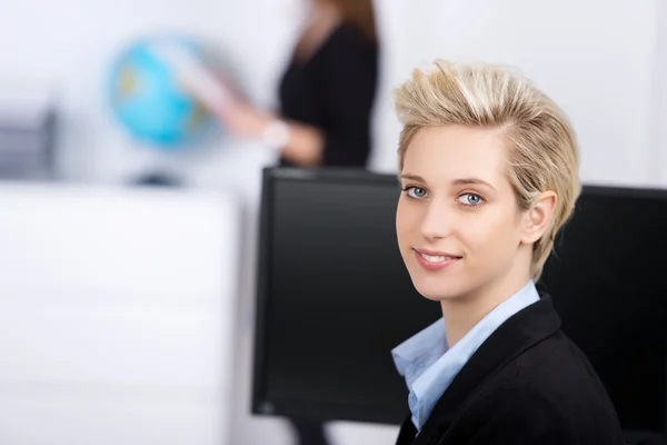 Lachende blond zakenvrouw in office — Stockfoto