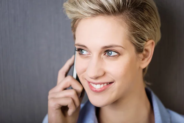 Zakenvrouw met behulp van mobiele telefoon terwijl u weg tegen muur — Stockfoto