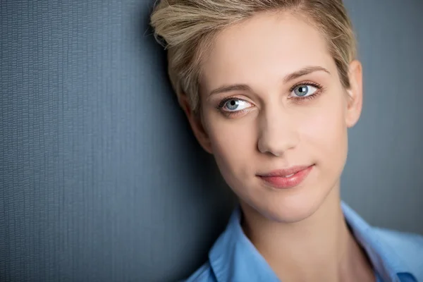 Femme d'affaires souriant tout en regardant loin contre le mur bleu — Photo