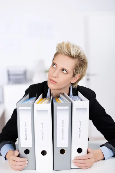 Tankeväckande affärskvinna med ringpärmar vid skrivbord — Stockfoto