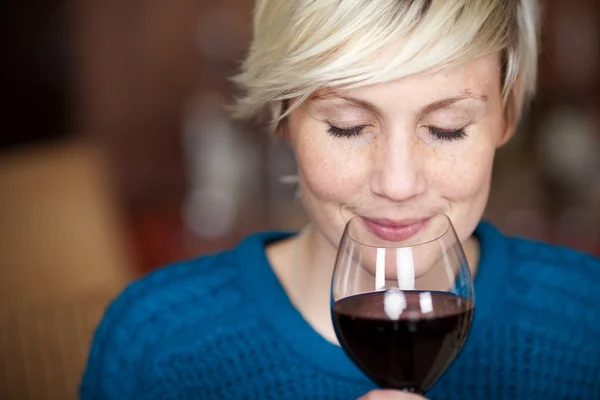 Cliente feminino bebendo vinho tinto com olhos fechados — Fotografia de Stock