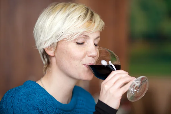 Mujer bebiendo vino tinto en restaurante — Foto de Stock