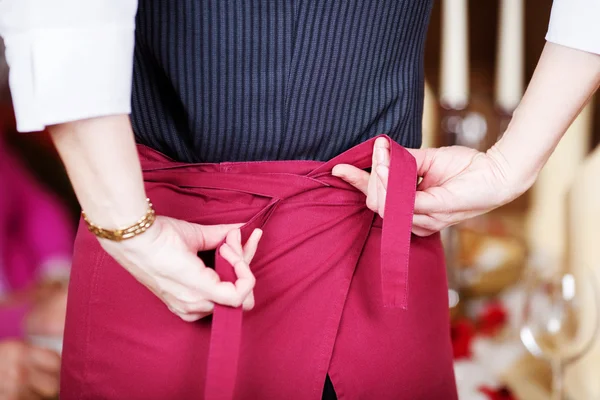 Waitress Tying Apron In Restaurant — Stock Photo, Image