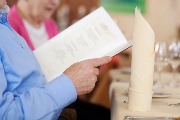 Пожилые пары смотрят меню — стоковое фото