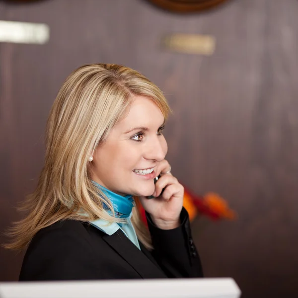 Recepcionista alegre usando telefone — Fotografia de Stock