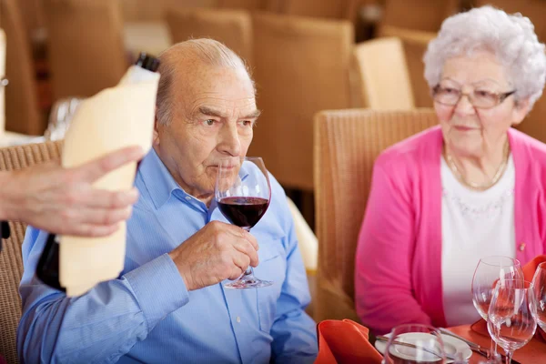 Uomo anziano degustando il vino nel ristorante — Foto Stock