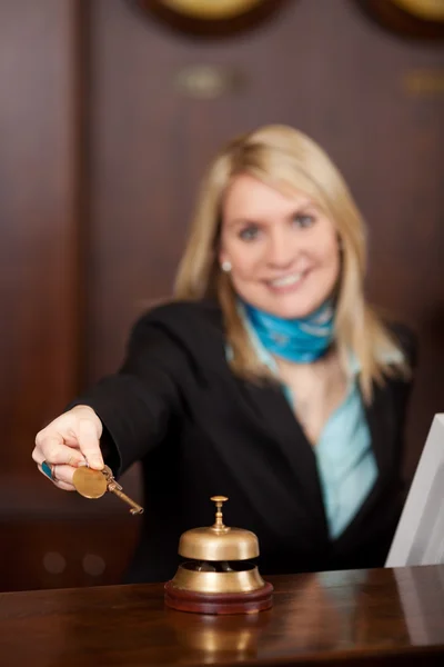 Recepcionista feliz dando llaves de la habitación al cliente — Foto de Stock