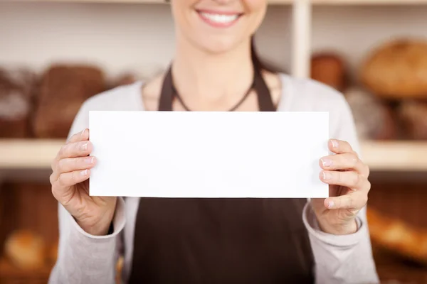 Bakery worker holding up a blank sign — Stock Photo, Image