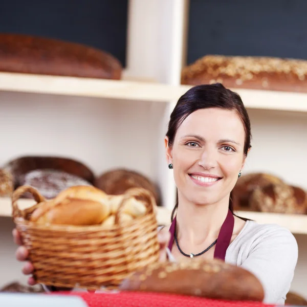 Vrouw met een mandje met verse broodjes — Stockfoto