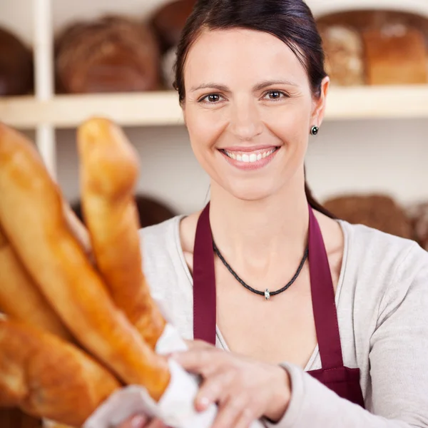 Lachende verkoopster in een bakkerij — Stockfoto