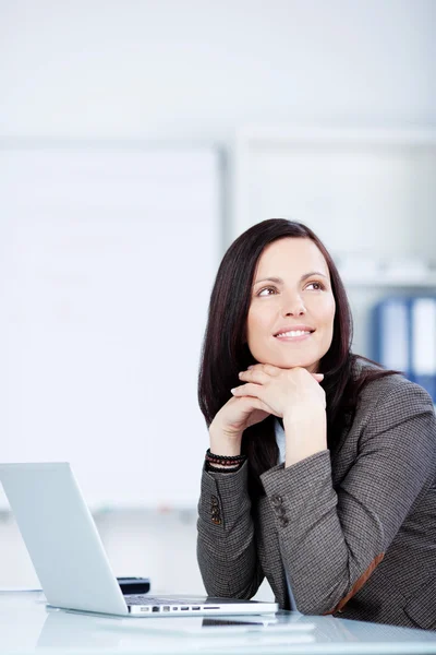 Pensive woman sitting at her desk — Stock Photo, Image