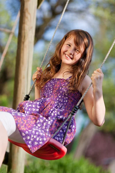 Jong meisje swingend in park — Stockfoto