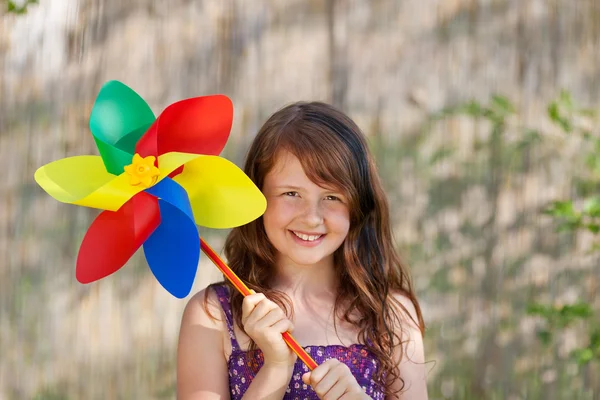 Menina segurando Pinwheel colorido no parque — Fotografia de Stock