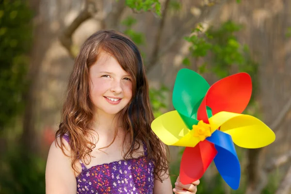 Sorrindo menina brincando com moinho de vento — Fotografia de Stock