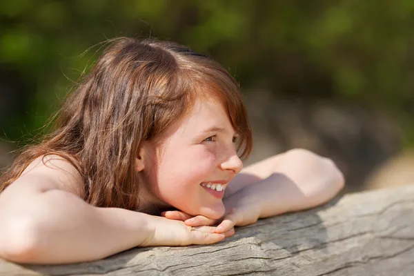 Meisje leunen ontspannen op de boomstam — Stockfoto