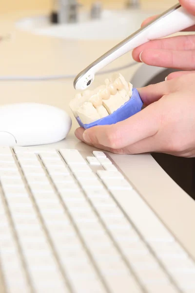 Dental technician examines teeth with a camera — Stockfoto