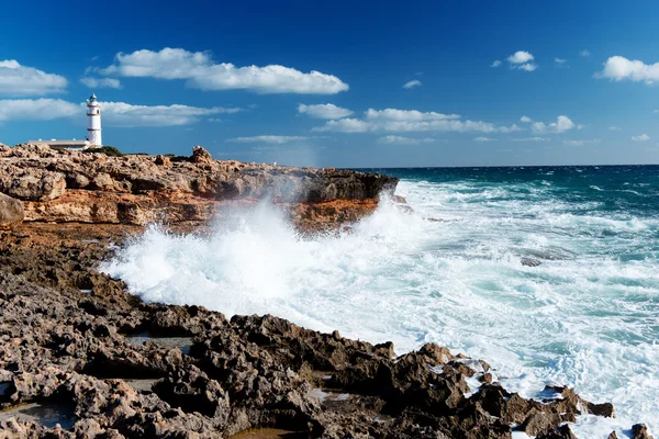 Ondas salpicando em rochas perto do farol — Fotografia de Stock