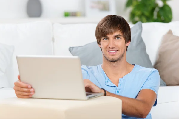 Hombre hirviendo con el ordenador portátil en casa — Foto de Stock