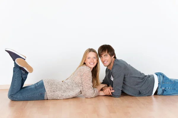 Couple lying on the floor head to head — Stock Photo, Image