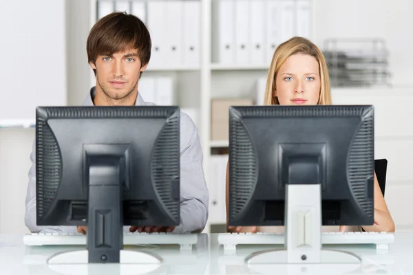 Hombre y mujer de negocios trabajando en computadoras — Foto de Stock