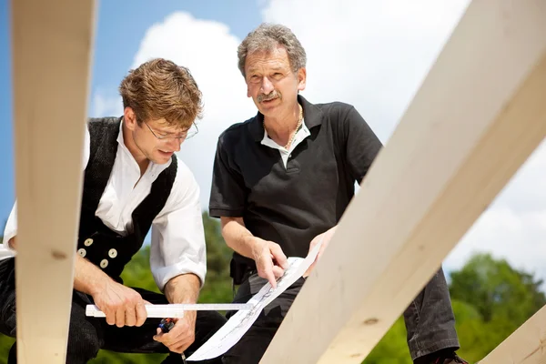 Arquitecto y carpintero discutiendo los planos azules — Foto de Stock