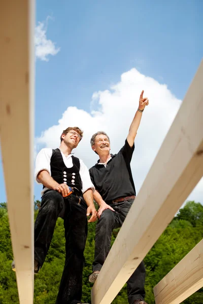 Two carpenters discussing the work on the roof — Stock Photo, Image