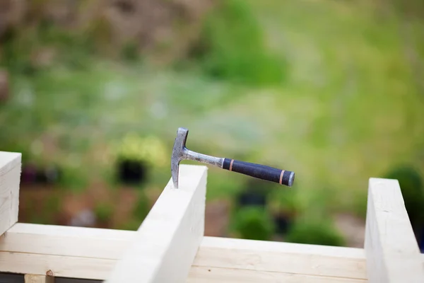 Carpenter hammer stuck in a beam — Stock Photo, Image